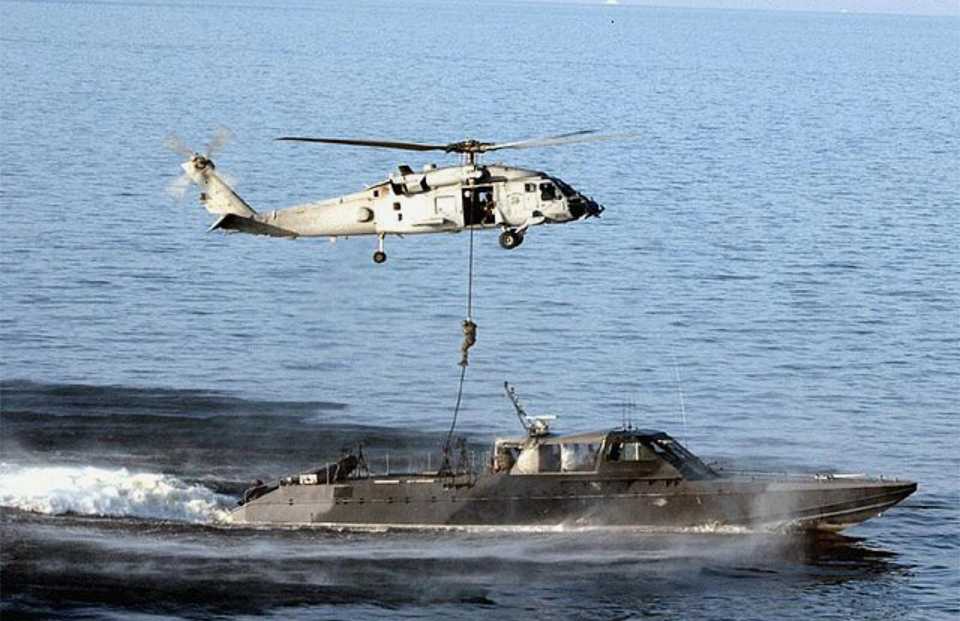 US Navy SEALs descend from an HH-60H belonging to the Red Wolf Helicopter Sea Combat Squadron (HSC-84) onto the Mk V SOC boat 