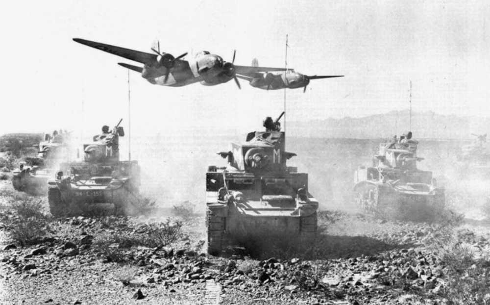 Two US A20 attack aircraft fly low over a group of M3 light tanks (older Stuart models) during training in California in 1942.