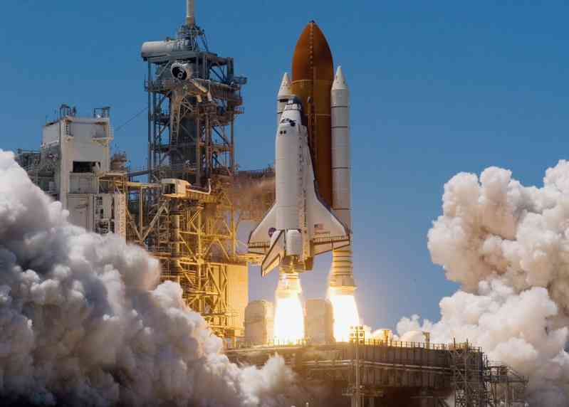 The Atlantis space shuttle ignited, with the bright tail and billowing smoke coming from the SRB 